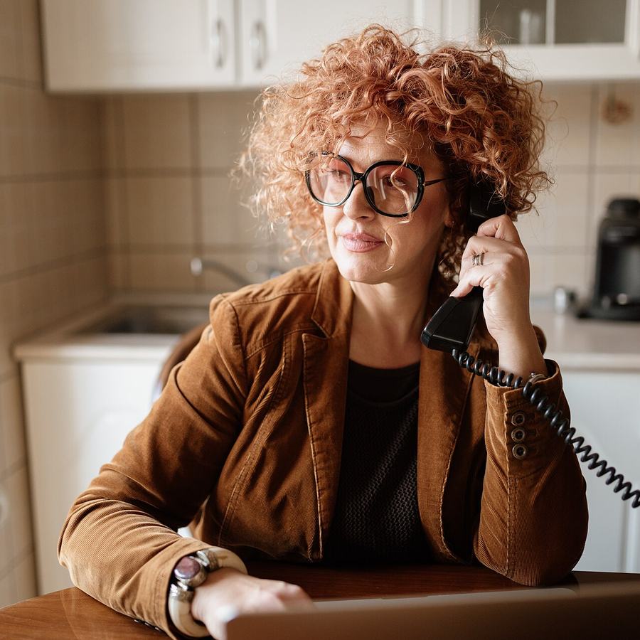 Femme au téléphone assise à une table
